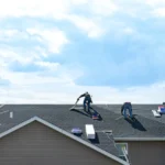 3 men working on an asphalt roof