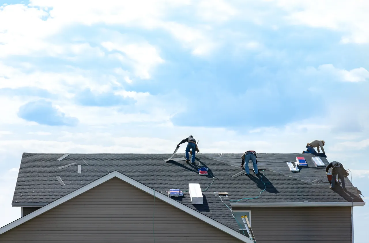 3 men working on an asphalt roof